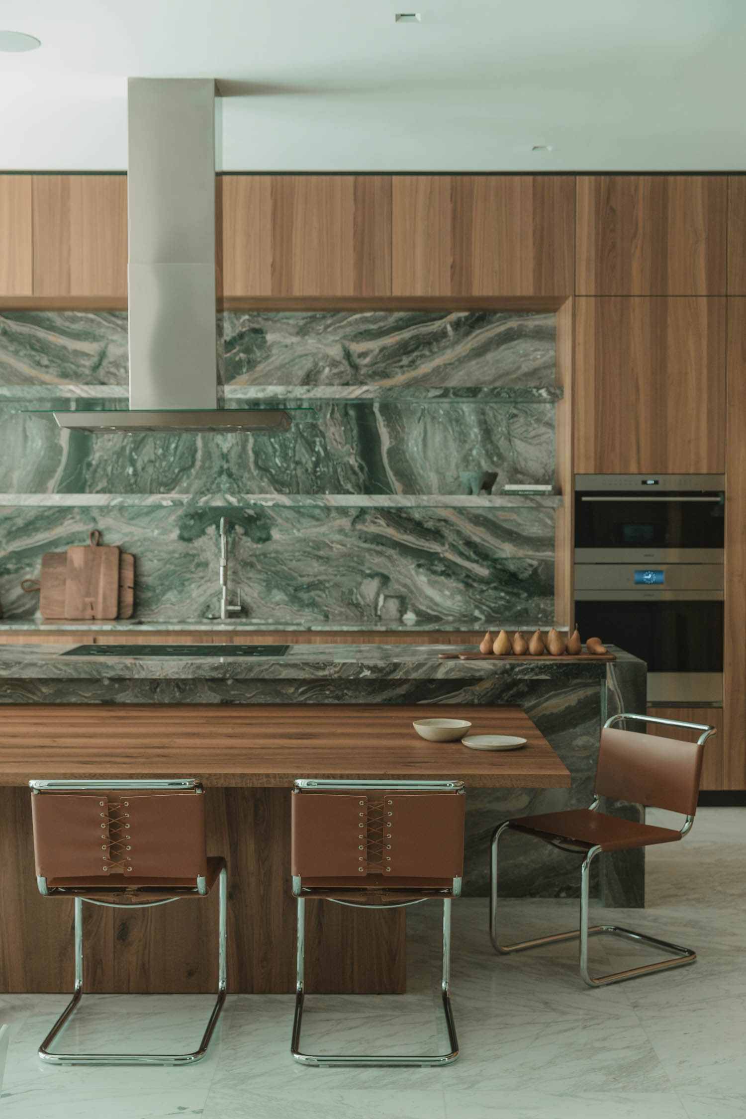 kitchen with marbled backdrop and wooden table
