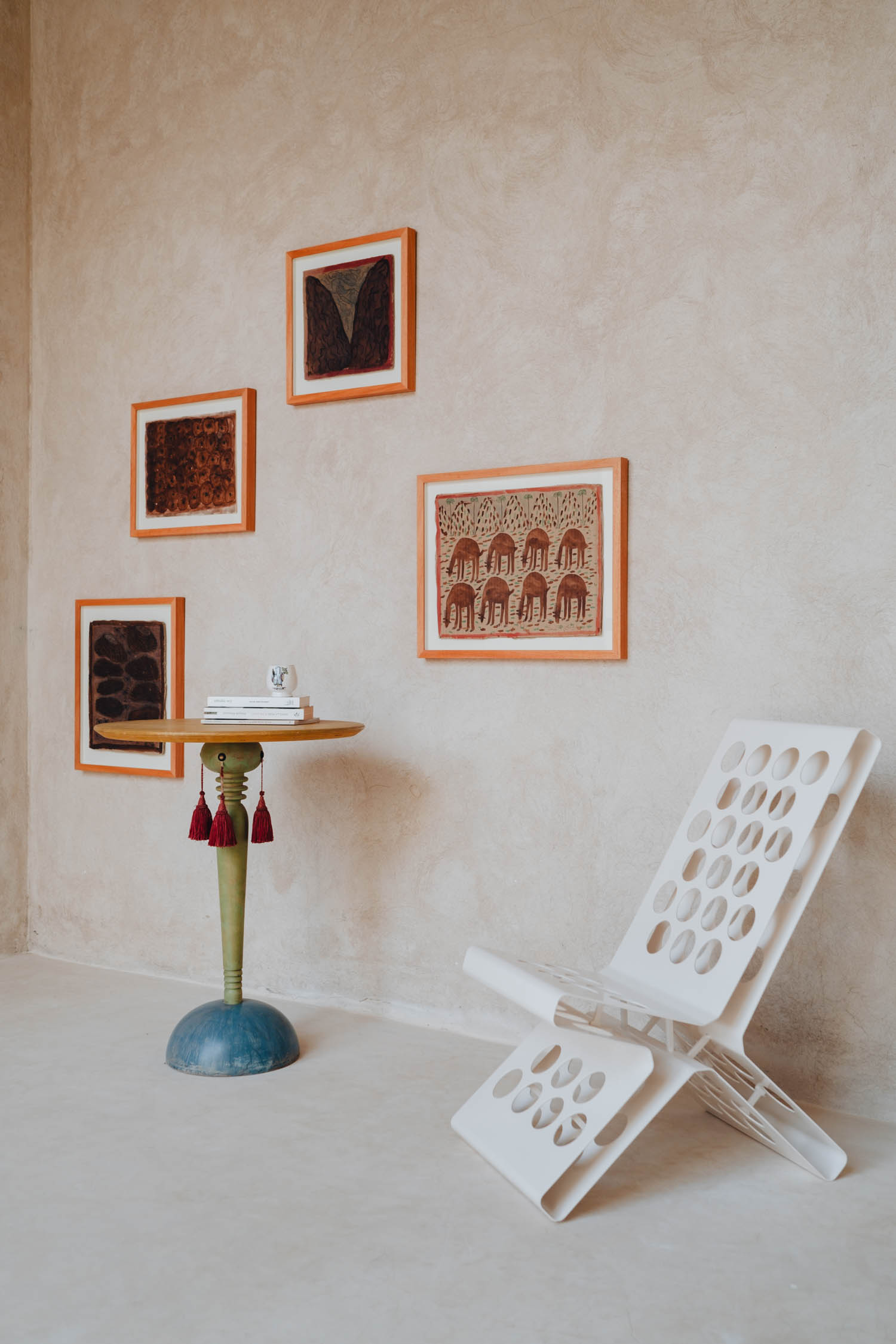 bedroom nook with four paintings and white chair