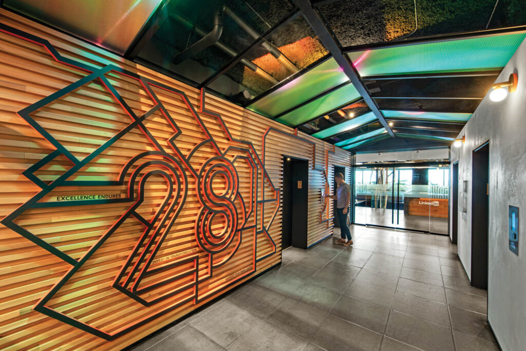 main elevator lobby with wooden slats on walls and bright wayfinding graphics