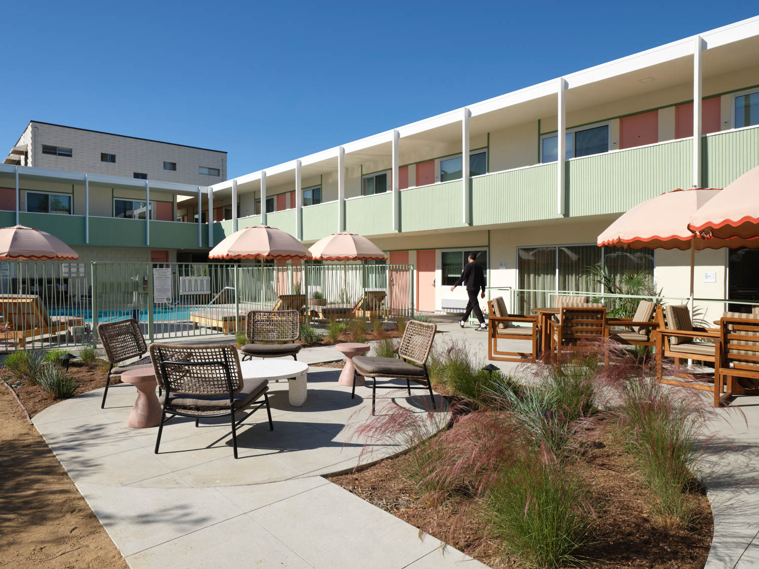 outdoor check in area with lots of chairs and pink umbrellas