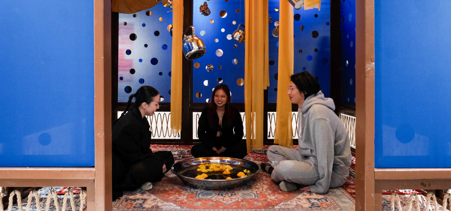three women sitting in a teahouse with blue wallpaper