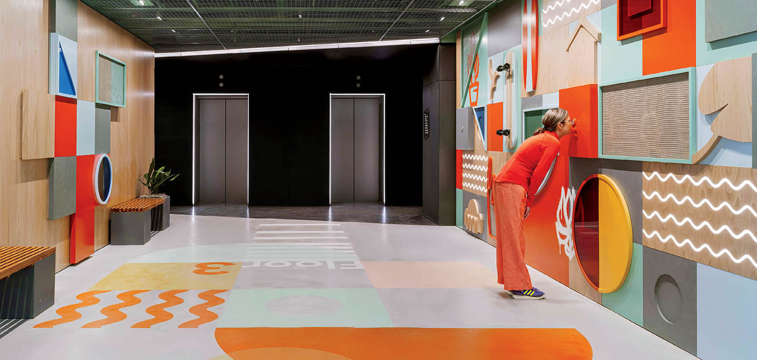 person peeking through a colorful mural